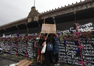 MÉXICO. Mujeres colocan flores y carteles con nombres de víctimas por feminicidios, en cercos metálicos instalados por el Gobierno.