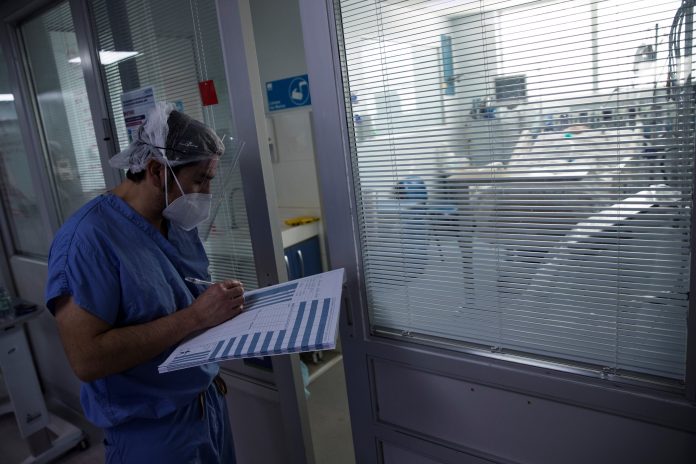 CASOS. Un médico revisa el estado de un paciente con Covid-19 en el hospital clínico de la Universidad de Chile, en Santiago. CASOS. Un médico revisa el estado de un paciente con Covid-19 en el hospital clínico de la Universidad de Chile, en Santiago.