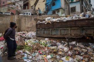 SITUACIÓN. Una mujer busca comida en la basura el 29 de marzo de 2021 en Caracas (Venezuela).