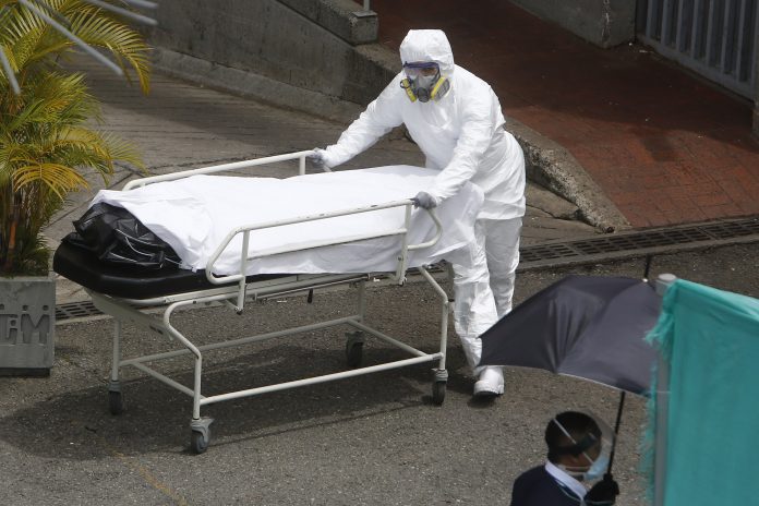 Casos. Personal sanitario transporta el cuerpo de una víctima Covid-19 en el Hospital General de Medellín (Colombia). (EFE) Casos. Personal sanitario transporta el cuerpo de una víctima Covid-19 en el Hospital General de Medellín (Colombia). (EFE)