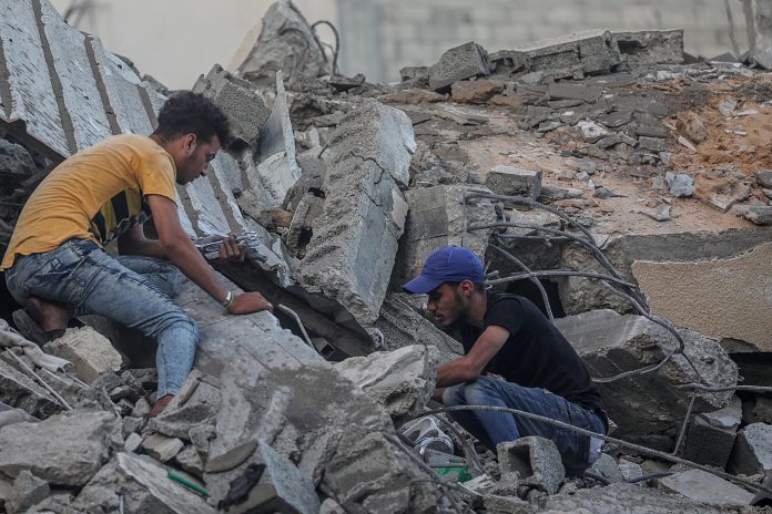 Víctimas. Palestinos inspeccionan los escombros de su casa destruida después de los ataques aéreos israelíes, en Gaza, el 19 de mayo de 2021. (EFE)